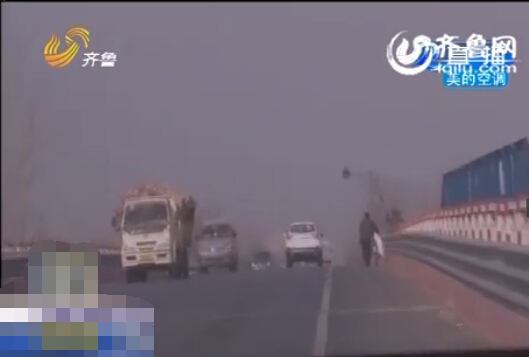 犯罪嫌疑人杀人后潜逃至江苏、河南，最后民警在310国道上发现了推着自行车前行的嫌疑人。（视频截图）