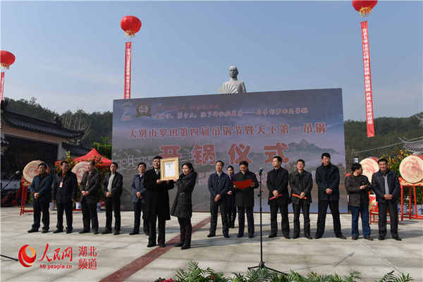 图为上海大世界基尼斯总部代表（左）向罗田县委书记肖燕梅（右）授牌）。