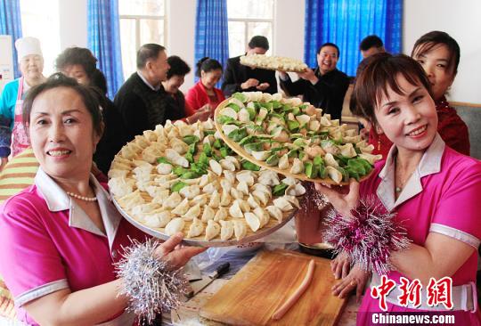 两位刚演出完的居民在展示大家包的饺子。　曹新加　摄