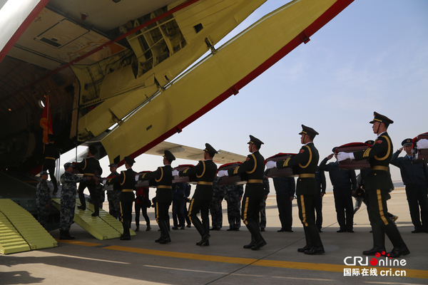 　　中方礼兵护送烈士遗骸登上中国人民解放军空军接运专机（摄影 安光浩）