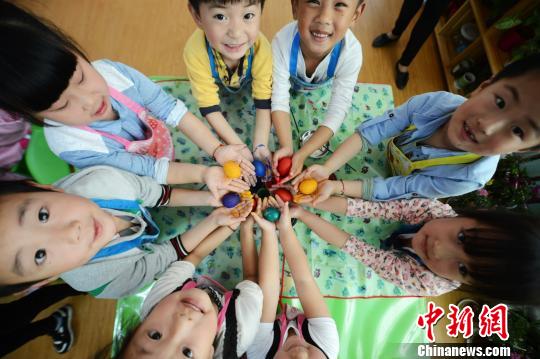 图为幼儿园的小朋友展示自己手绘的七彩斗蛋。 孟德龙 摄 5月6日是二十四节气中的立夏,扬州民间有吃立夏蛋绘彩蛋斗蛋等习俗,当日,江苏扬州市杉湾花园社区杉湾幼儿园的小朋友手绘七彩斗蛋,体味传统民俗。据悉,扬州立夏民间还有多种习俗,如立夏有称人的习俗,就是称体重。立夏称人会给人带来福气,人们也祈求秤人的吉利话给他们带来好运。