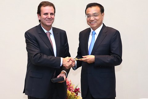 当地时间5月20日下午,国务院总理李克强在下榻饭店会见巴西里约热内卢市市长帕埃斯。帕埃斯代表里约市政府和人民,向李克强授予里约热内卢城市钥匙。图/新华社