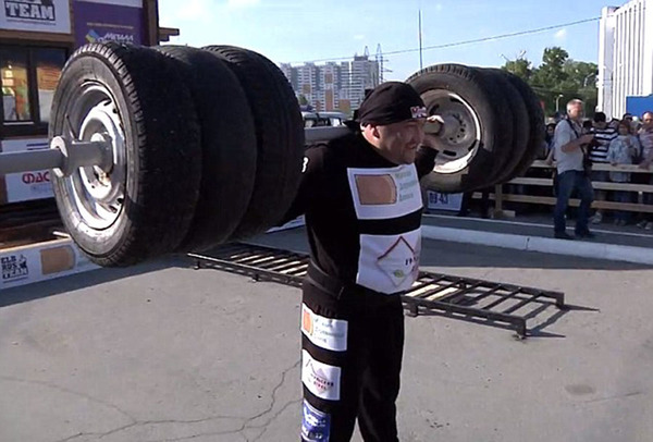 俄罗斯大力士尼格马图林蹲举6个沉重的轮胎热身，准备挑战世界纪录（网页截图）