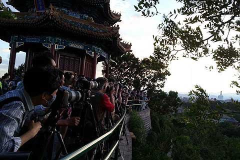 游客爬上制高点万春亭用相机拍“北京蓝”。景山公园供图