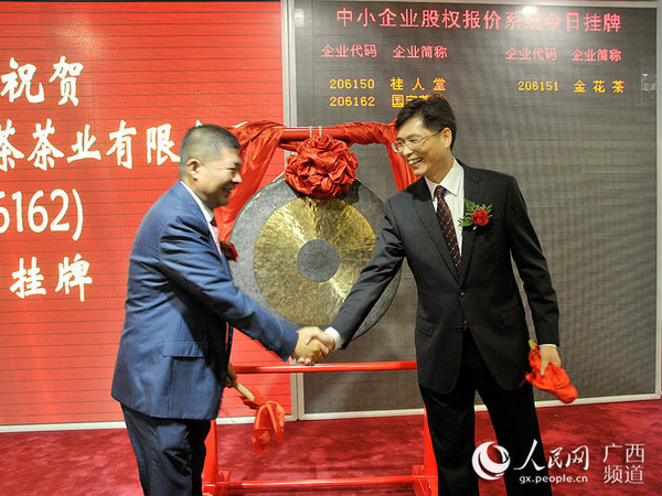 防城港市政协主席赵发旗与桂人堂集团董事长刘志新为国宝茶叶挂牌上市敲锣