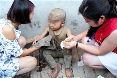 近日，河南濮阳志愿者为男童擦身。志愿者看到网络图片后，探访男童家，发现孩子满头伤，7岁不会说话。志愿者供图