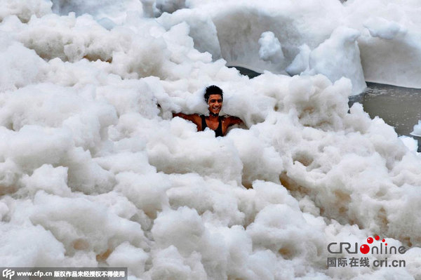 当地时间2015年7月12日,印度诺伊达,亚穆纳河河岸泛起厚厚的泡沫。这主要是由于工业污染物排放在河里导致河水高氨含量。图片来源:CFP