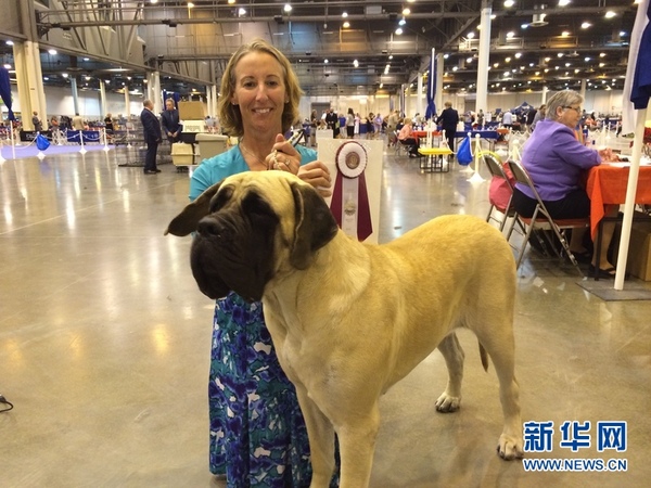 一位女士与自己获奖的爱犬合影。（新华网记者　张永兴　摄）