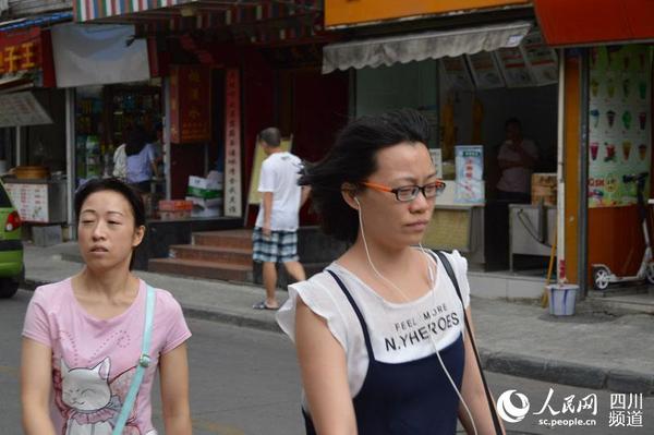 市民迎大风出行，感受凉爽天气。王波 摄