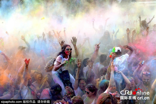 当地时间2015年8月8日,西班牙马德里,马德里民众街头欢度酒红节(Holi Festival),5000民众狂撒500公斤彩色粉末,新鲜花瓣来庆祝这一节日。图片来源:sipaphoto