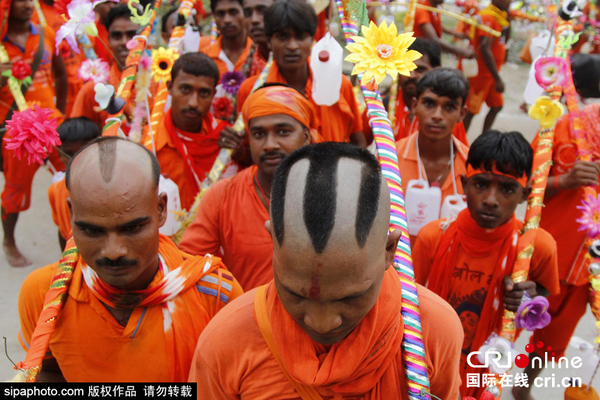 　　当地时间2015年8月10日，印度阿拉哈巴德，印度信徒“kanwarias”在前往金庙（Kashi Vishvanath temple）朝拜前在恒河将他们的壶灌满水。图片来源：SipaPhoto