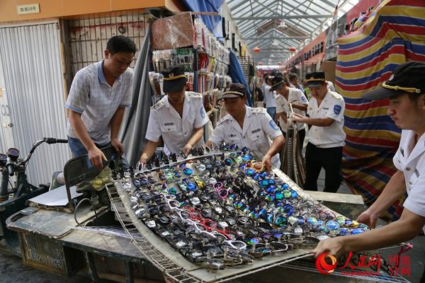 执法人员拆除占道经营摊位