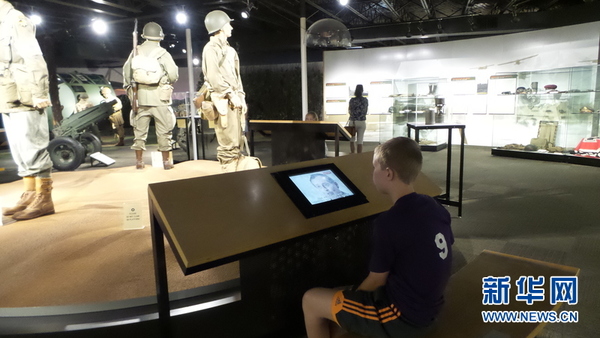 一位男孩正在通过影像资料了解滑翔机战斗人相关情况。新华社记者张永兴摄