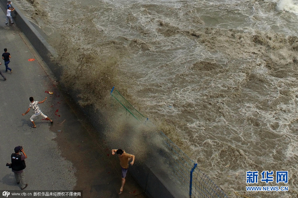 　　    2015年08月29日，杭州，农历七月十六，钱塘江秋季潮汛再起。钱江潮在杭州下沙一处江堤翻卷上岸，扑向观潮的人群，吓得观潮客四散奔逃。图片来源：cfp