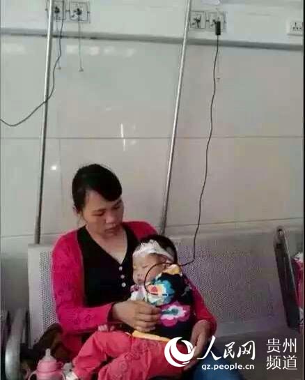 图为谢君华静静地躺在妈妈的怀里接受治疗。