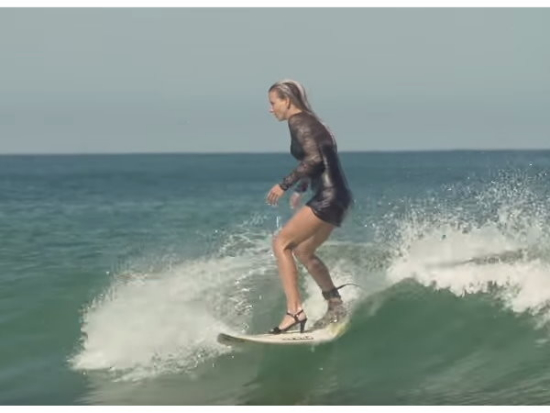 外国辣妹打赌输了 信守承诺穿礼服高跟鞋冲浪