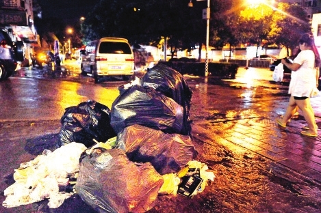 6日晚10点半,福州江厝路旁,大堆的垃圾打包好,放在路边等待垃圾车清运