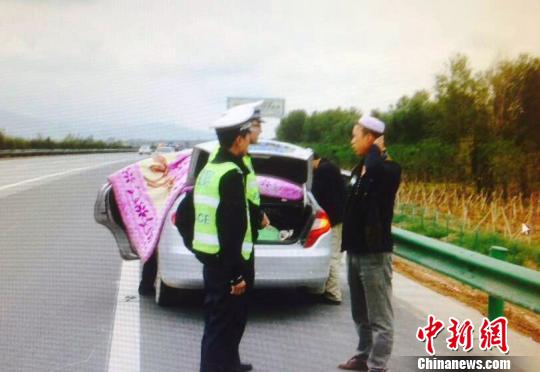 民警协助孕妇家人在私家车上搭建的简易“产房”。 马福 摄