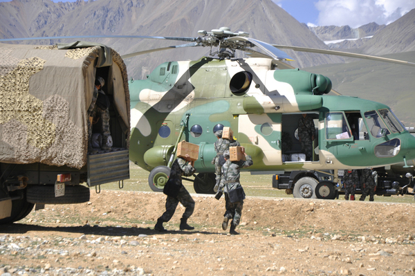 某军需保障组正在给起直升机上搬运物资。李伟明 摄