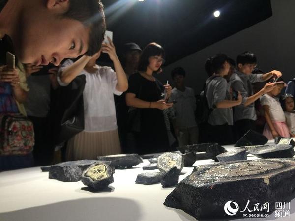 市民正在仔细观看3D打印艺术作品。