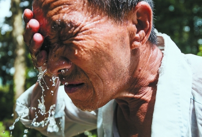 每次巡山老陈都要走上近两个小时，在炎热的夏日里，老陈不停地用水清洗脸部，好让自己保持凉爽。
