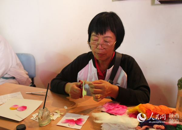 张宝兰女士正在制作棉絮画,其作品被誉为东方