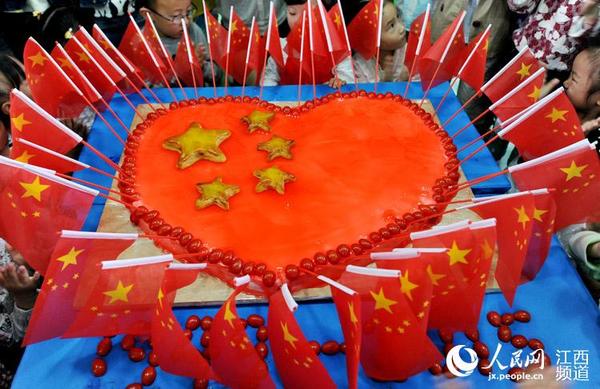 江西省德兴市银城幼儿园小朋友们在老师和阿姨的帮助下,制做爱心卡通月饼,喜迎中秋、国庆节的到来。 人民网德兴9月25日电 25日,江西省德兴市银城幼儿园小朋友们在老师和阿姨的帮助下,制做爱心卡通月饼,喜迎中秋、国庆节的到来。 当天,江西省德兴市银城幼儿园大班的小朋友们在老师和阿姨的帮助下,用水果、面粉、奶油和果酱等原料,制做了一个创意十足、直径为1米的爱心卡通月饼,不仅培养了小朋友们从小热爱祖国、热爱劳动的行为养成,同时为即将到来的我国传统中秋佳节和国庆66华诞增添了几份喜庆色彩。