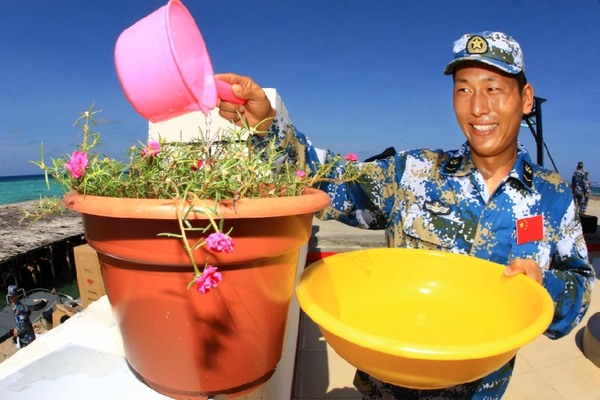 南沙东门礁的一名战士在为“太阳花”浇水。 新华社记者 查春明 摄