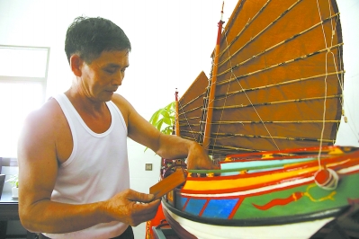 郑水土在制作木帆船模型。
