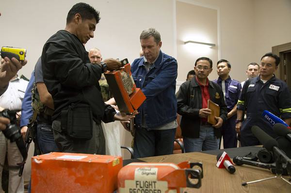 　　↑2014年7月22日，马来西亚调查人员（左）接过马航MH17航班客机的黑匣子。