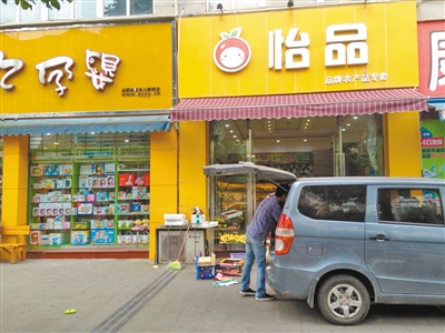 康女士为了遮挡污水专门给店门口安了雨棚。 记者 敖一航 摄