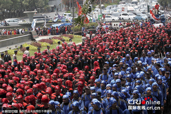 　　当地时间2015年10月15日，印尼雅加达有成千上万的印尼工人和劳工活动家向总统府方向游行，抗议工厂工人失业率增加，基本生活物资价格上涨。 图片来源：CFP