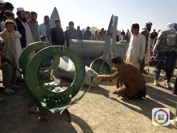 　　阿富汗塔利班武装分子与坠落的美军F16战斗机部件“合影”。（图片来源：新华/法新）　　
