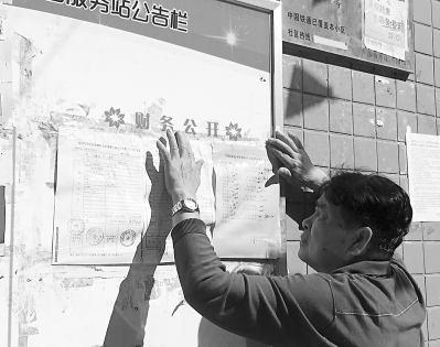 每个月公开财务，是福州三保园小区“家园中心”最重视的事。图为蔡依伯正在粘贴账目明细表。