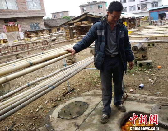 当地柿饼加工基地广西桂林平乐县二塘镇牛角村委西水车村，村民黄建发目前至少放了2万斤坏坏掉的鲜果柿子到沼气池里。　欧惠兰　摄