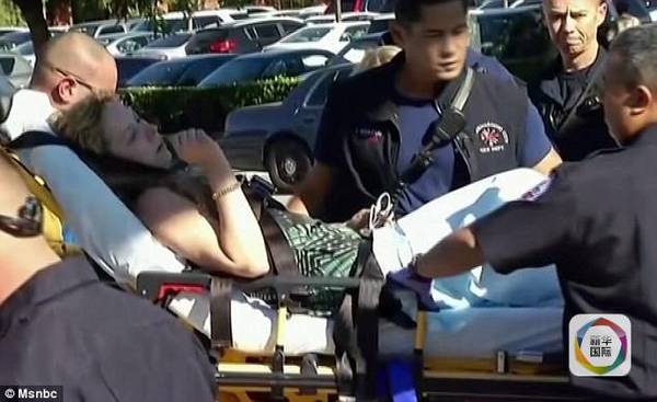 　　一名被嫌犯击中的伤员正被救援人员抬出康复中心，准备进行救治。