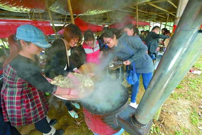 游客自己动手做柴火饭。