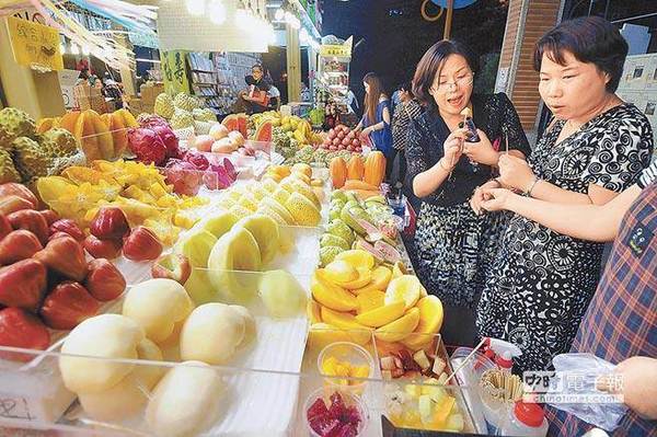 台湾“大选”逼近,外传陆客团赴台数量锐减。图为陆客在台湾水果摊位前试吃。(本报系资料照片)图片来源:台湾《中时电子报》