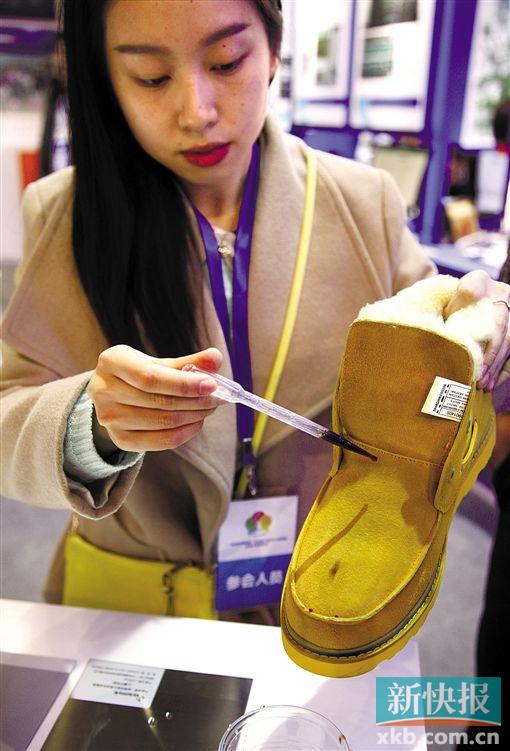 ■参展商展示经过纳米涂层技术处理后的鞋子。新快报记者 李小萌/摄