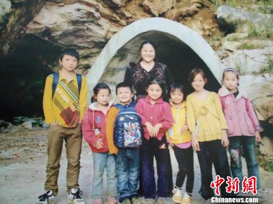 邓迎香和孩子们站在麻怀隧道前。　邓迎香供图　摄