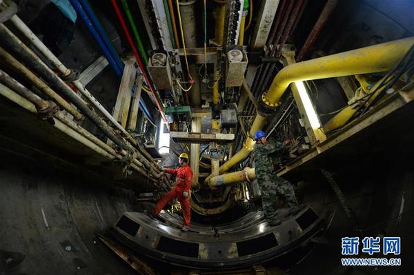 12月31日,两名施工人员在隧道盾构机内作业。 新华社记者 陈斌 摄