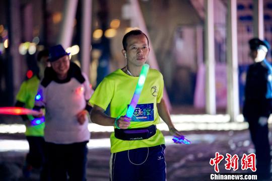 图为跑者戴上五彩斑斓的荧光装备参加公益跑活动。　李南轩　摄
