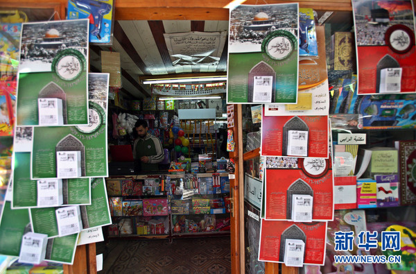 1月5日,纳布卢斯,巴勒斯坦年轻人和他的小杂货店,门前挂满了2016年挂历。新华网发(埃曼·纳巴尼摄)