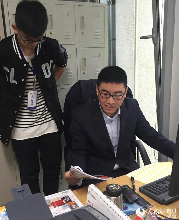 图为图书馆工作人员指导杨靖维如何分流编号。周栩如 摄
