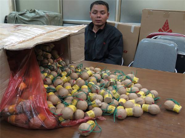 图为越南平福省警方抓获的走私烟花爆竹嫌犯及其走私的中国产礼花弹。
