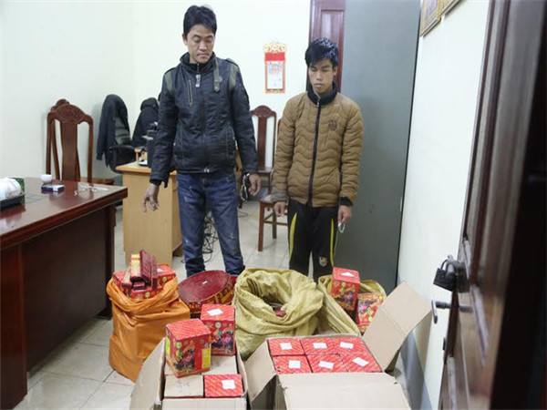 图为越南谅山省警方抓获的走私爆竹嫌犯和查获的走私烟花。