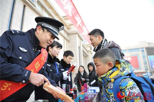 民警向小旅客宣传安全小常识，提醒不要携带和燃放鞭炮。