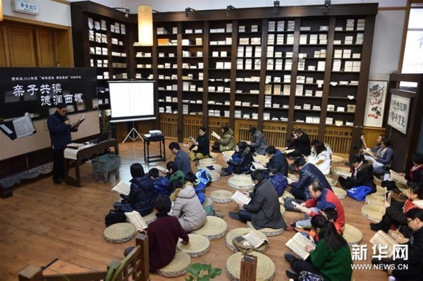 1月23日,书法家张本义(左)带领学生和家长诵读《孝经》。