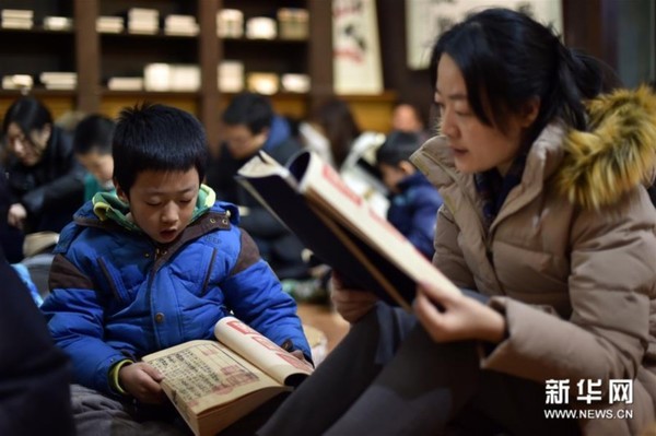 1月23日，一名小男孩在母亲的陪伴下诵读《孝经》。