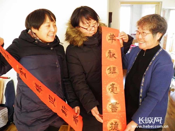 街道志愿者将写好的春联送到优秀党员家中。